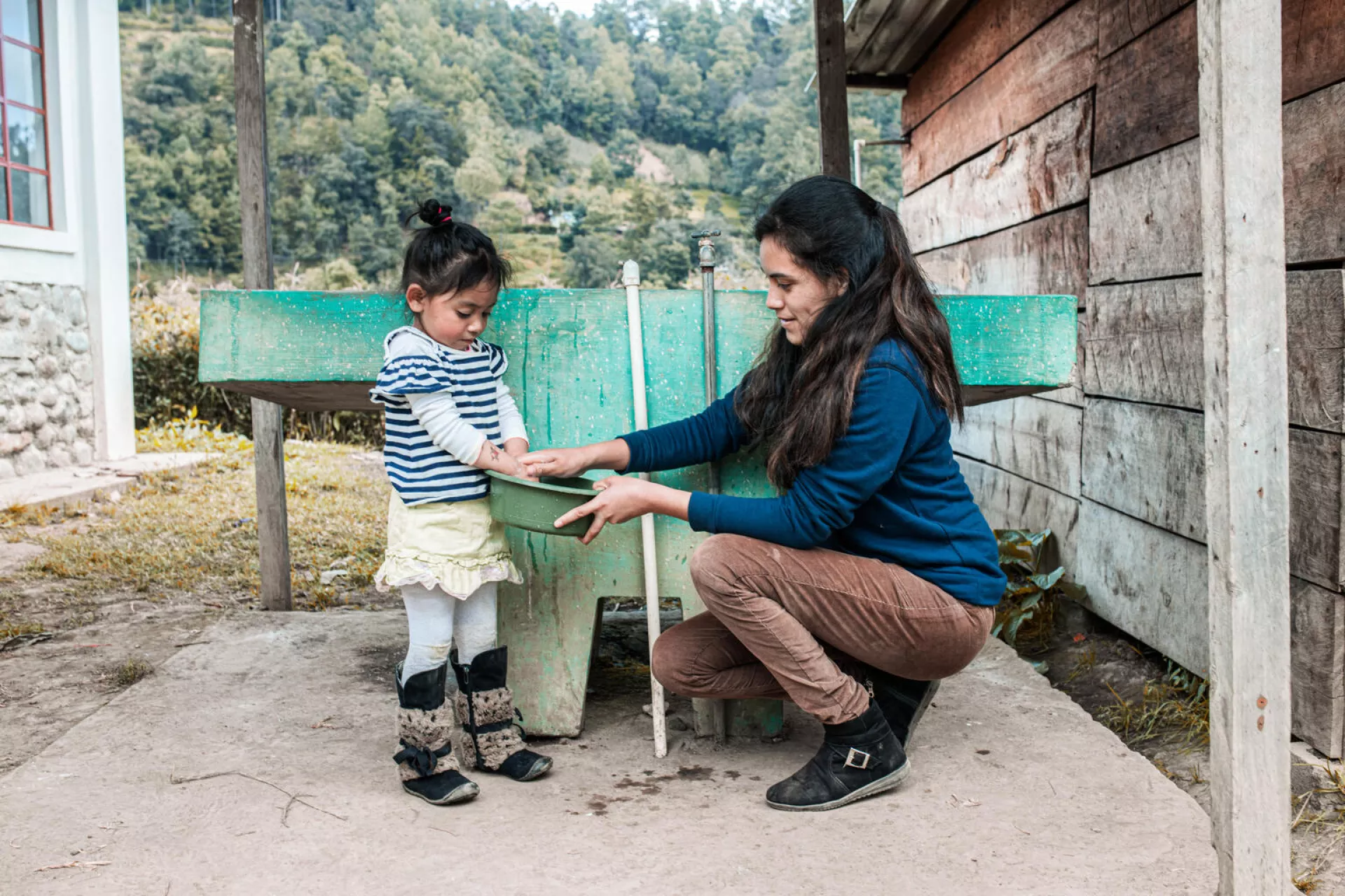 Ana Yancy Solis Melida washes the hands of her daughter Fatima Gabriel Solis after participating in a workshop supported by UNICEF
