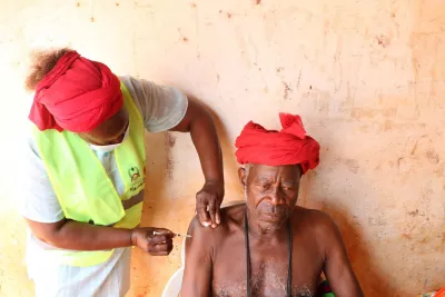 An older man sitting down and getting vaccinated