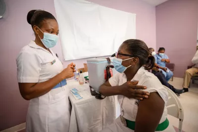 Nurse holds up sleeve to receive COVID-19 shot