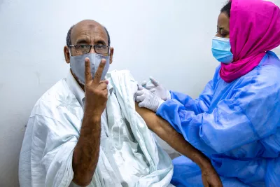 Man holding up a 'V' with his fingers as he gets vaccinated against COVID-19
