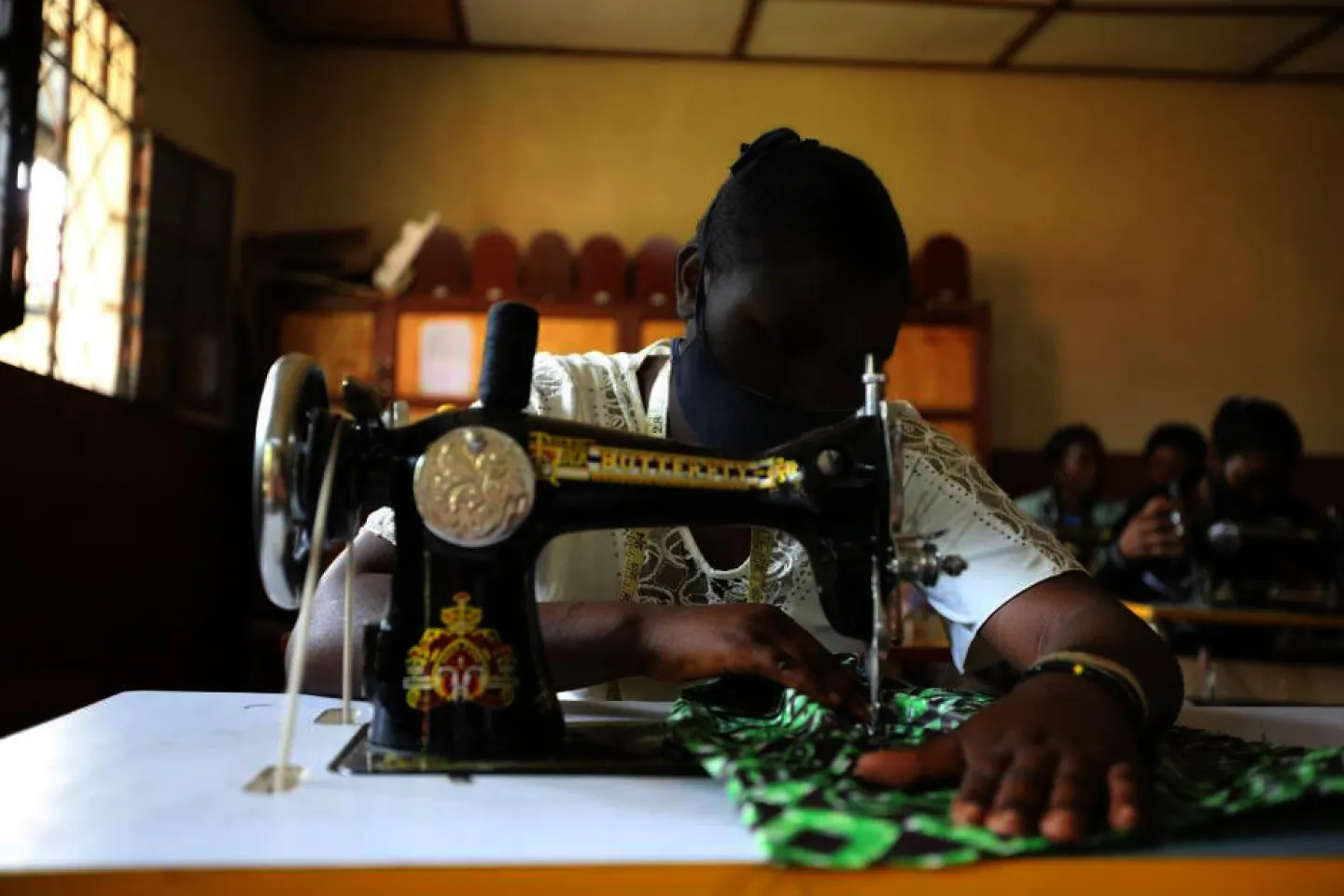 A young girl using a sewing machine