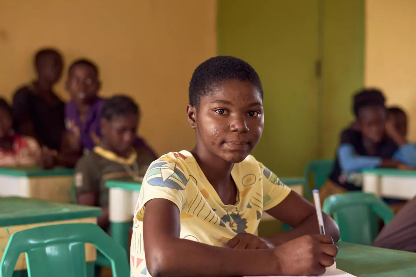 Portrait of an adolescent girl sitting at her desk in a classroom