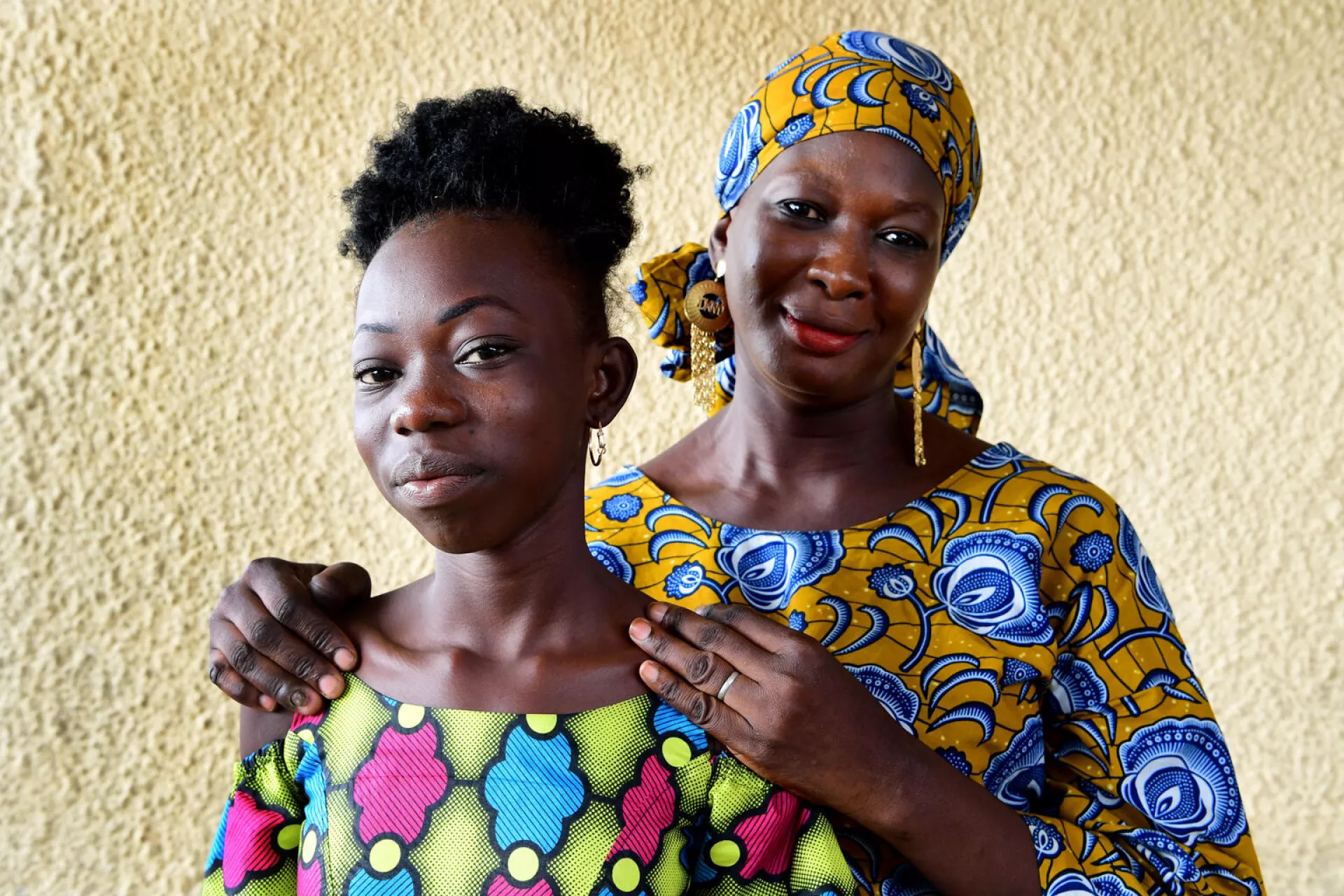 A portrait of a mother and adolescent daughter smiling