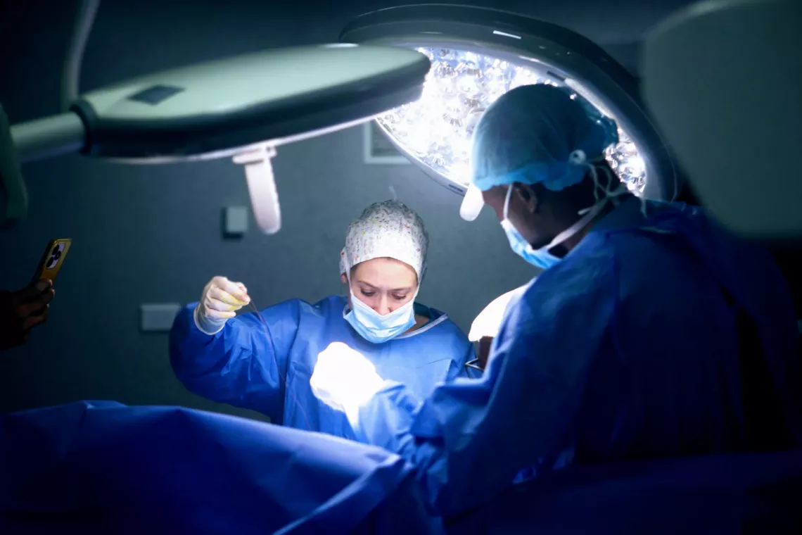 A female surgeon performing an operation with a male surgeon