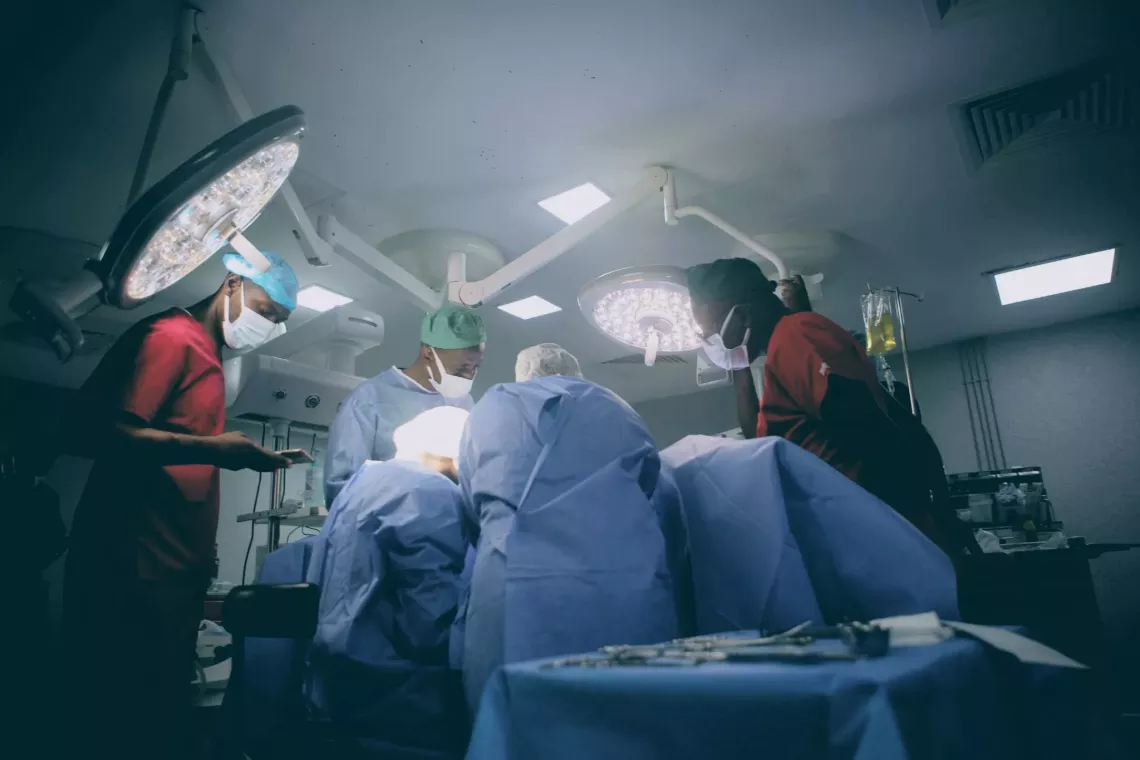 Medical professionals wearing their medical gowns and masks in an operation room performing a surgery
