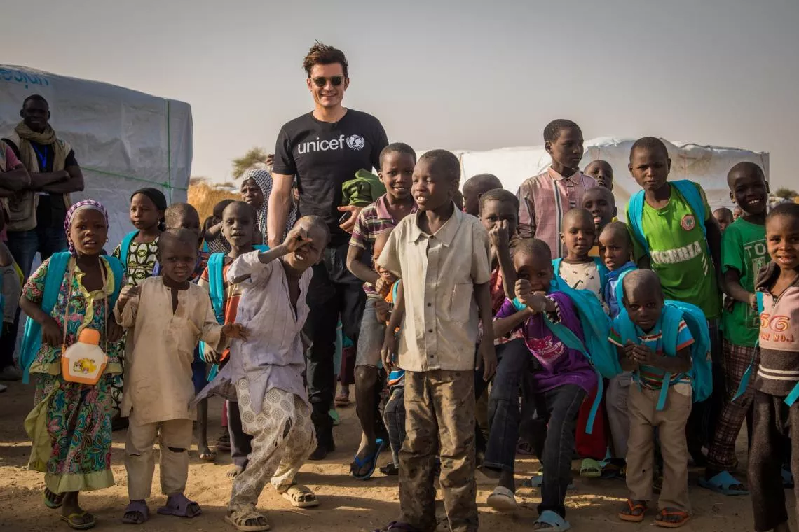 UNICEF Goodwill Ambassador Orlando Bloom (centre) stands with students following their classes at a temporary learning space at a camp for internally displaced people in Ngagam, near Diffa, Niger, Friday 17 February 2017.