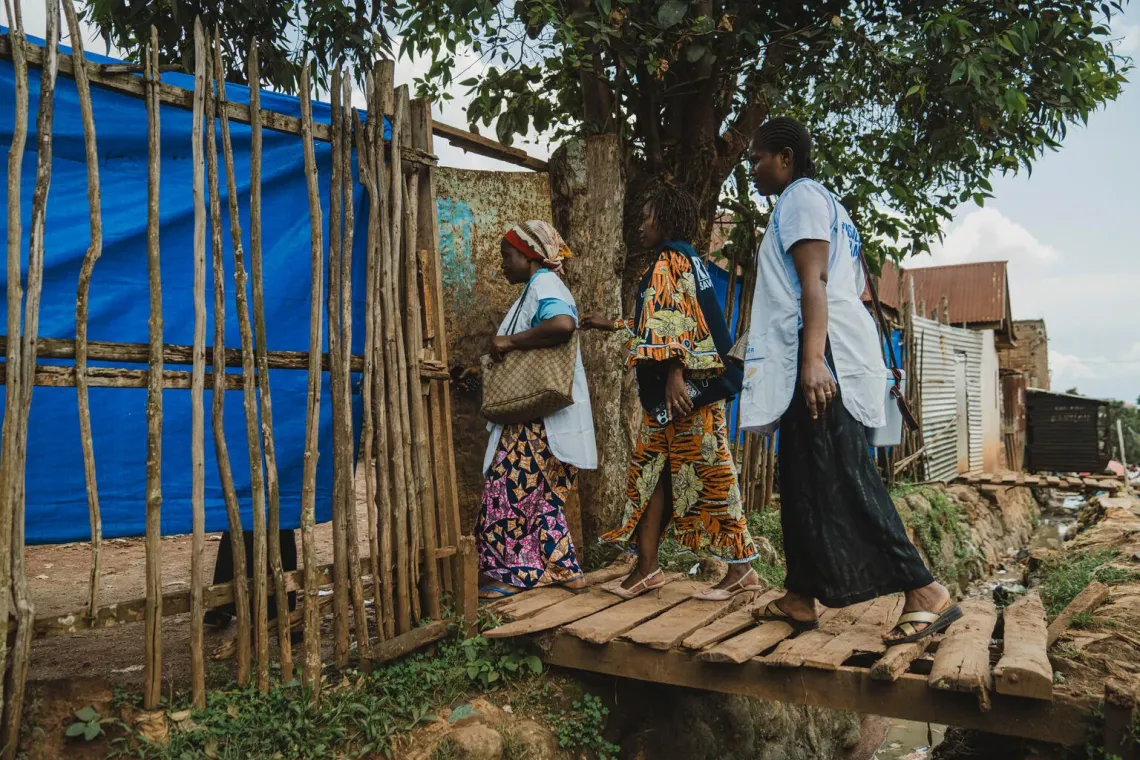 Une &eacute;quipe de vaccination qui traverse un petit pont en bois