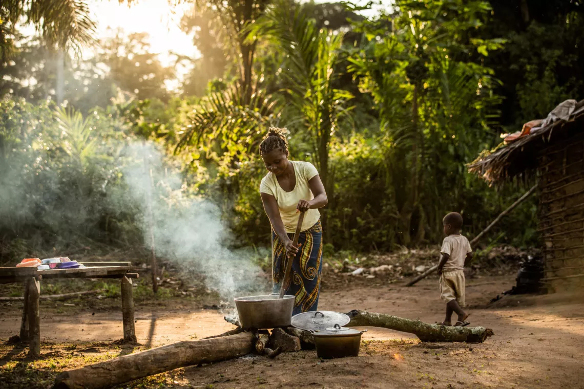 Woman cooking while her child is walking by