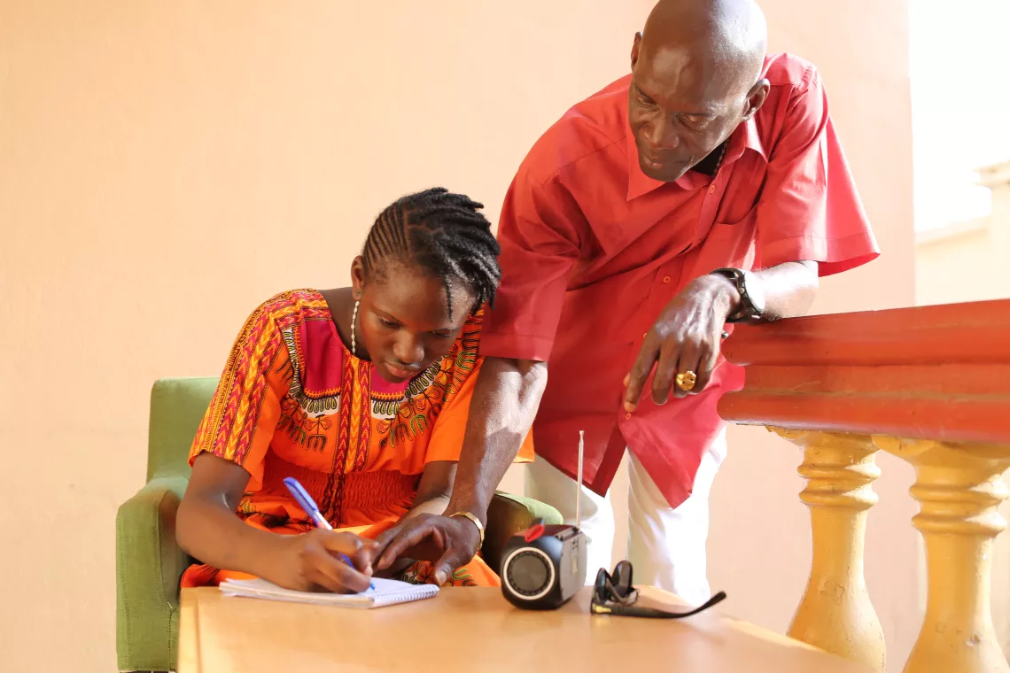 Father helps his daughter with her school work at home