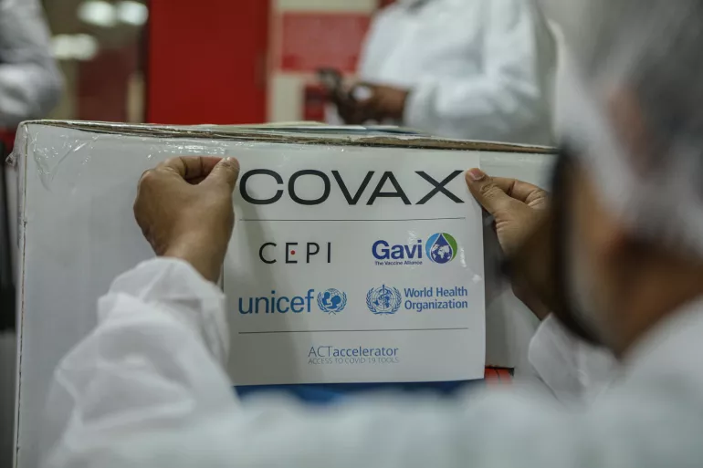 An employee packs and prepares for shipment a box containing COVID-19 vaccines