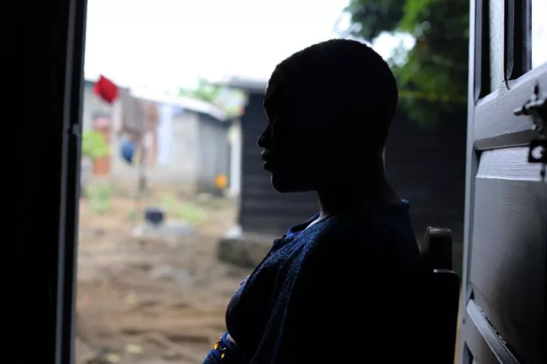 Silhouette of a young woman sitting down