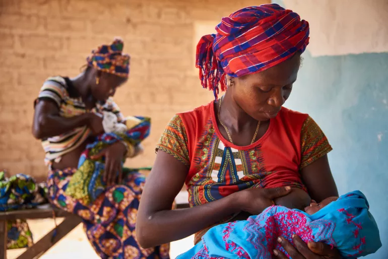 On 28 March, (foreground) Tenneh Mansaray breastfeeds her son, 9-day-old Manso Turay, in Bambaya Village in Fiama Chiefdom, Kono District.