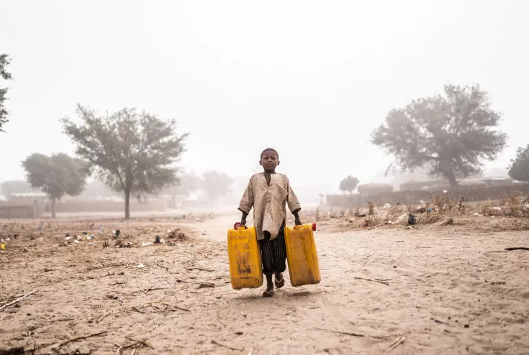A boy fetch water for his family and the Nigerian refugee family they are hosting at their home in Maradi, Niger.