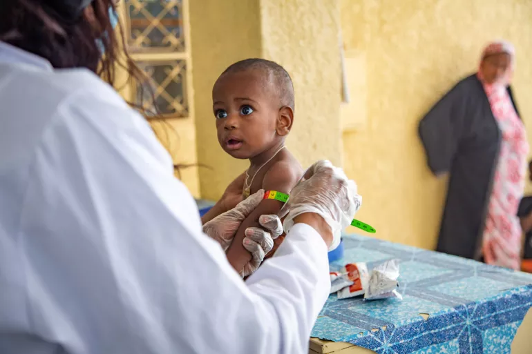 Une infirmiere qui verifie le tour du bras d'un enfant