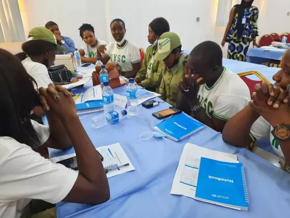Des jeunes assis autour d'une table en train de travailler