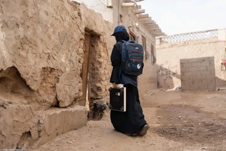A health worker travels from house to house in a village, helping families access essential health and nutrition services.