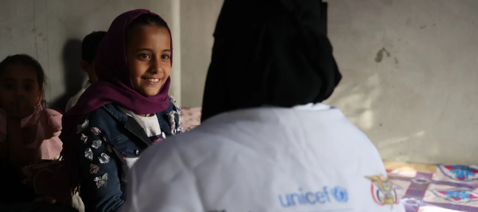 A warm smile is shared between Walaa and community health worker Belqees Ahmed