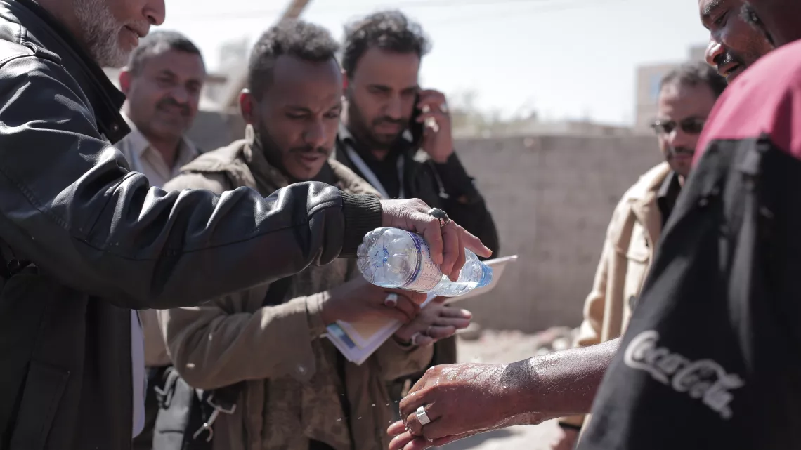 A community volunteer speaks teachers best handwashing practices in the Dar Selm community in Sanaa