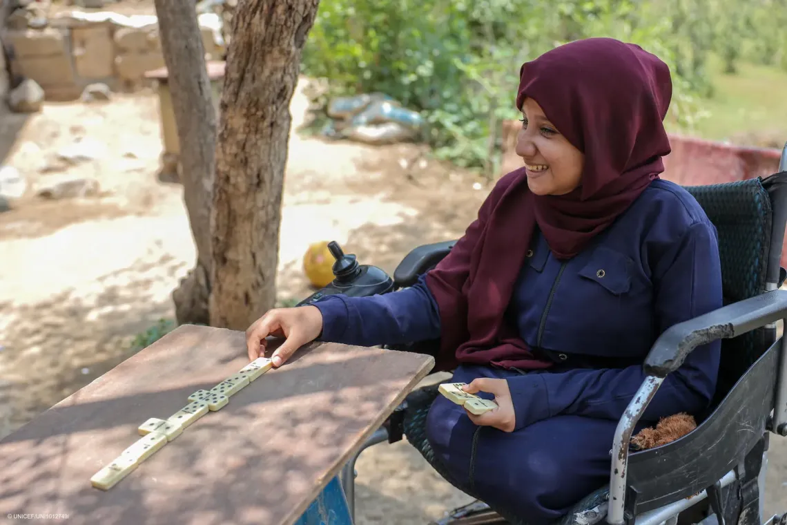 A disabled girl plays dominoes.