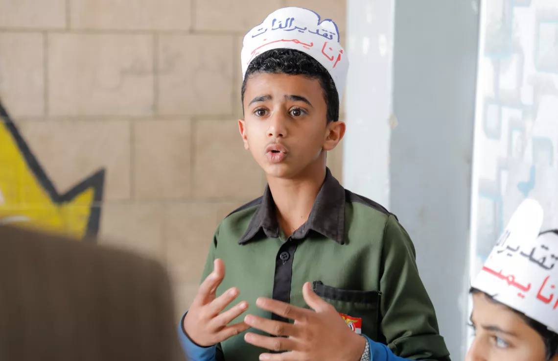a boy speaking in a workshop