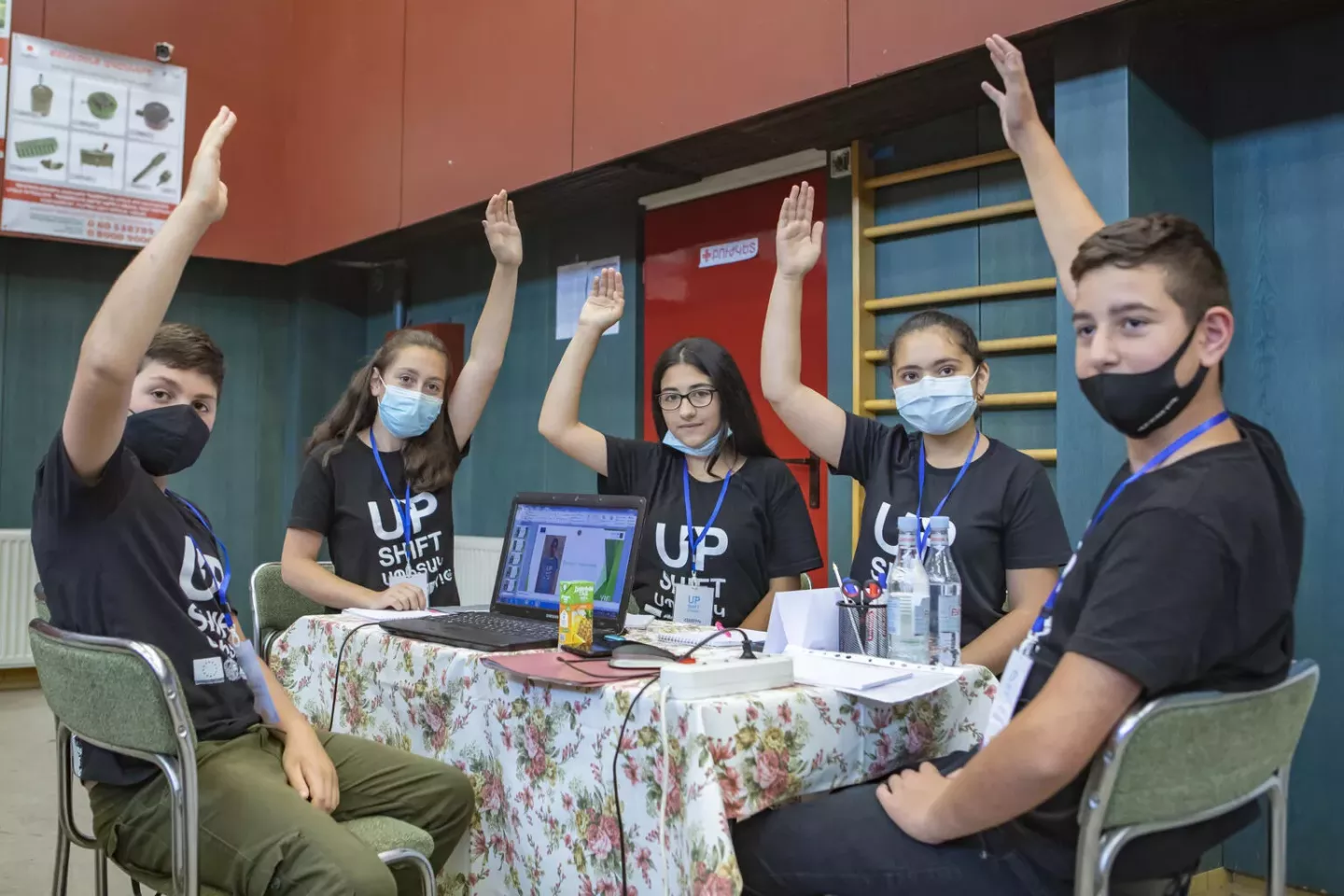 A photograph of a group of young people during an Upshift session in Armenia, with their hands raised