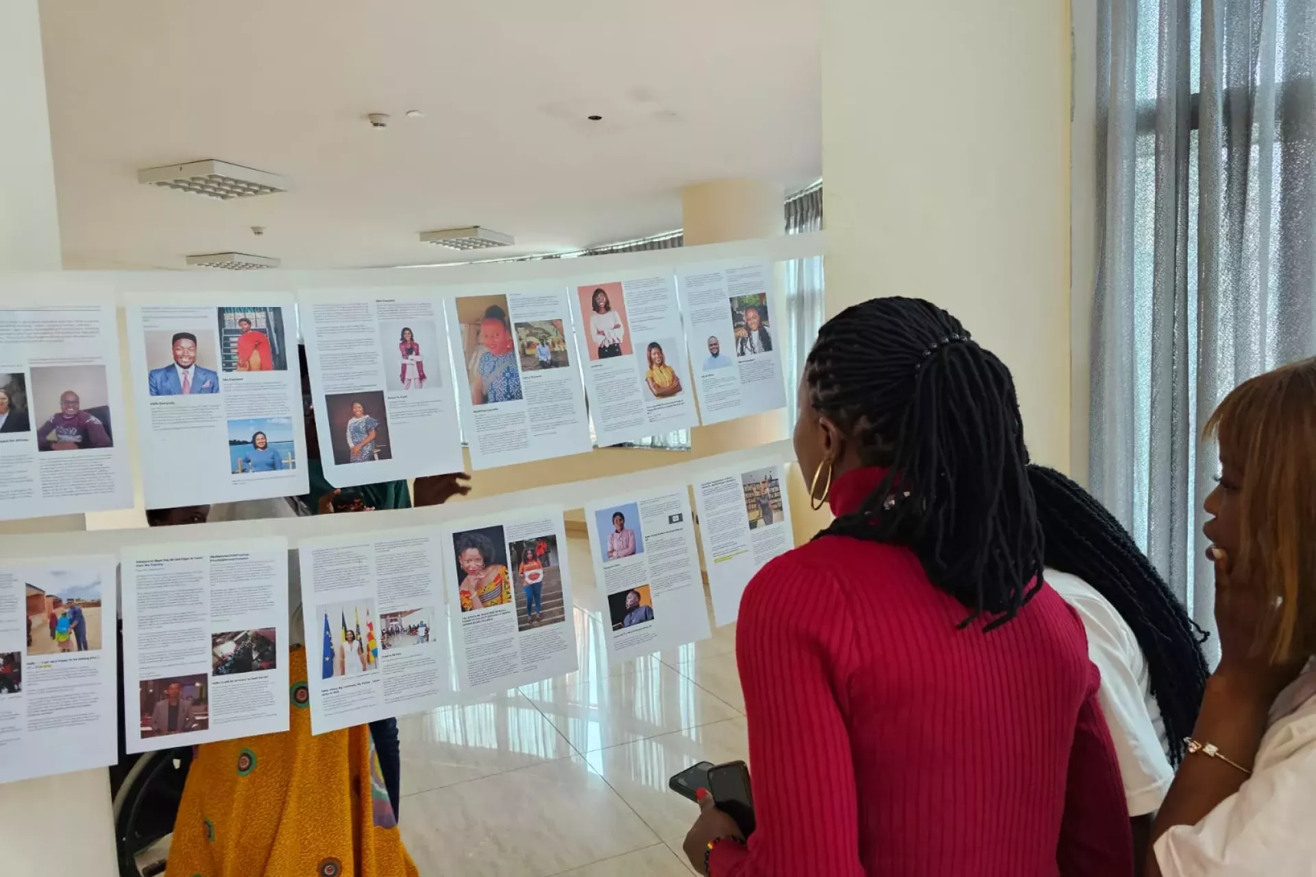 A photograph of a young woman looking at documents hanging on a string