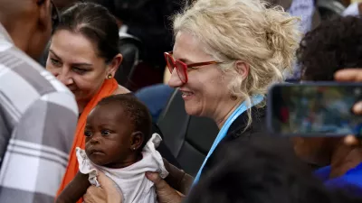 A woman lifting a baby.