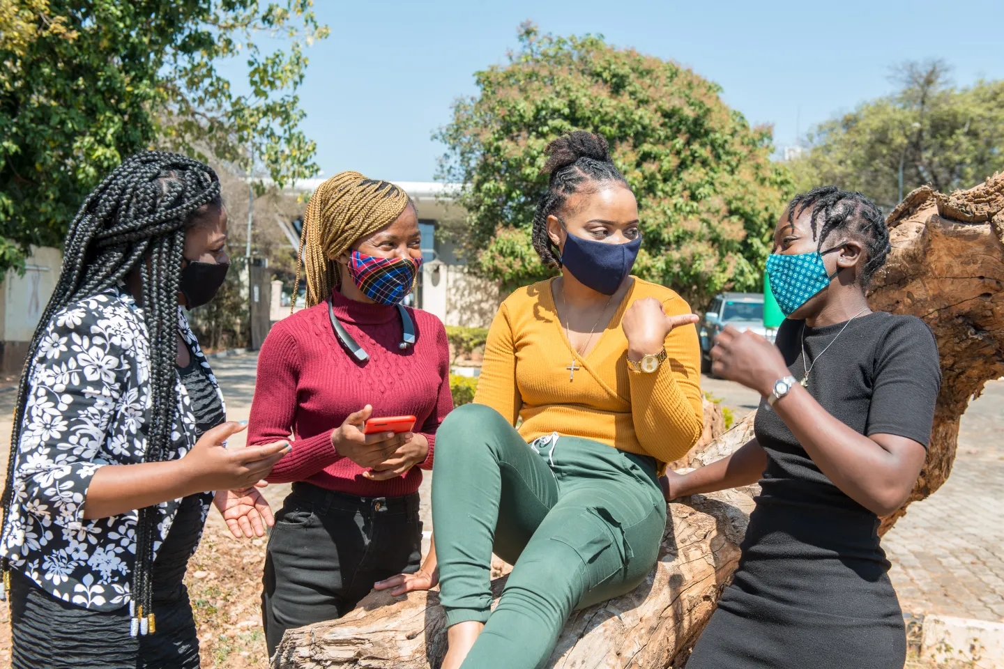 Four young women in Lusaka chatting outside.