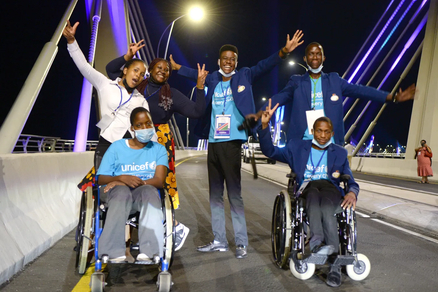 Six children on a bridge at night smiling