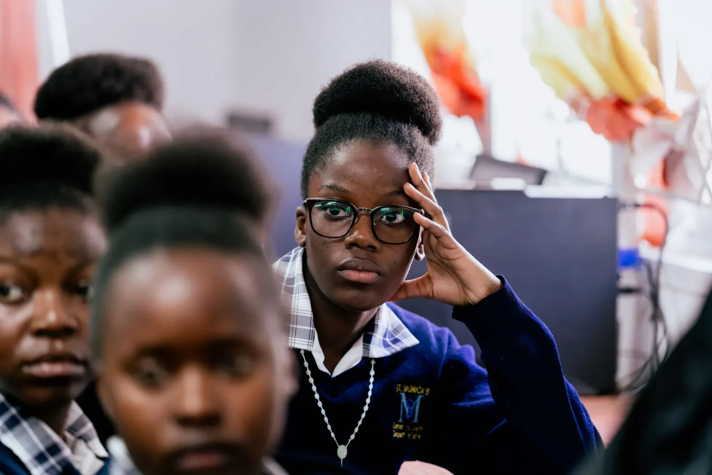 A learner at St. Monica's Girls' Secondary School listens attentively during a classroom lesson.