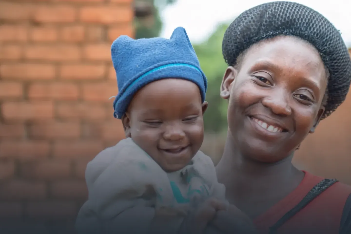 Mother and child pose for a photo in front of their Home