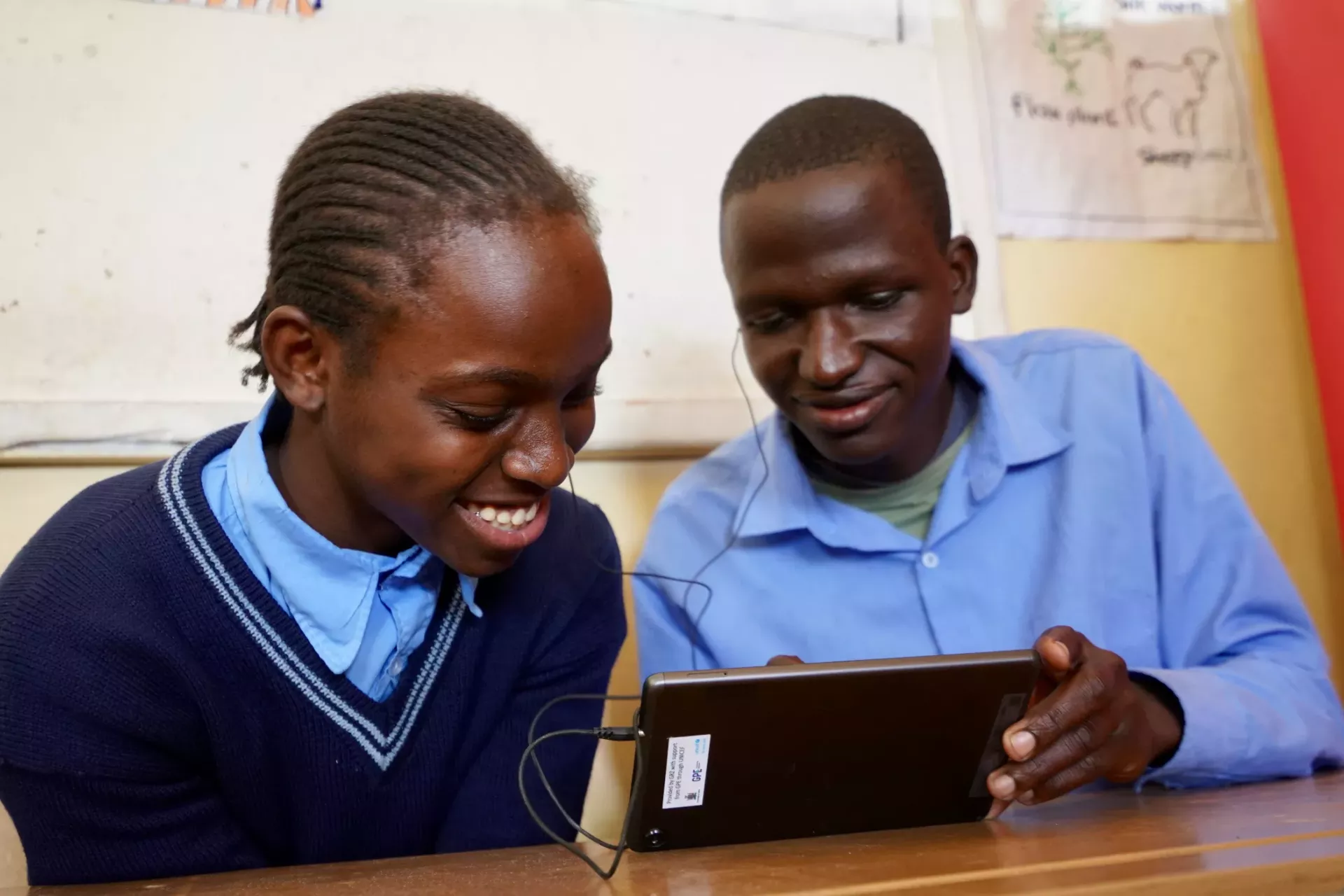 Mercy and Chrispin at UTH Special School learning through the Learning Passport on a tablet