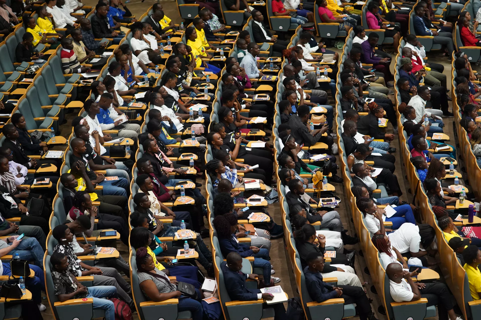 A picture of youths seated in a big conference room.