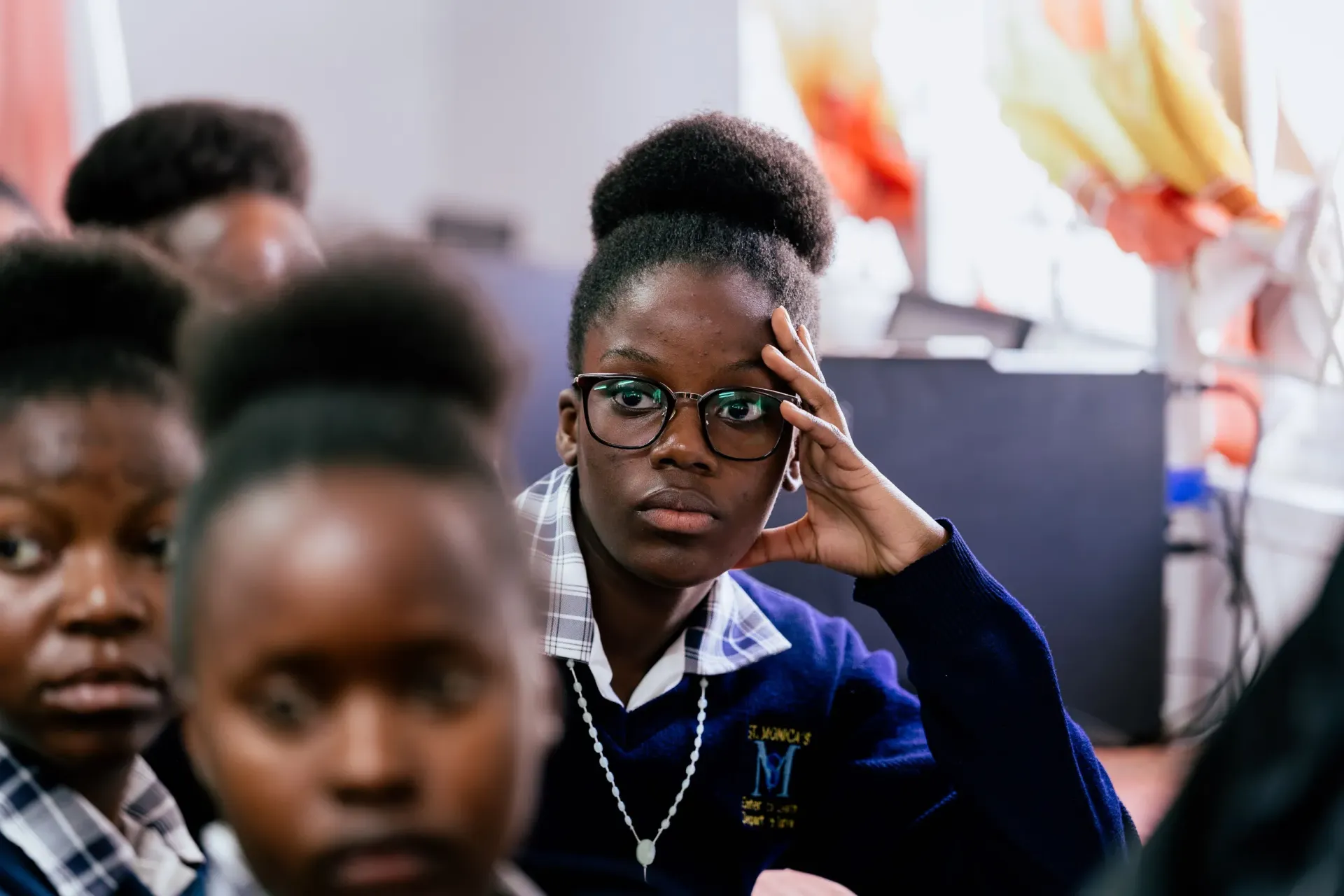 A learner at St. Monica's Girls' Secondary School listens attentively during a classroom lesson.