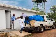 People off-loading boxes from a vehicle