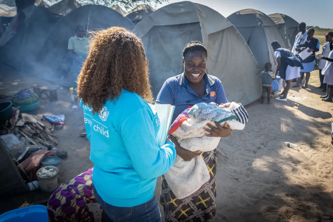 Nalishebo Munali, holding her one-month old baby, speaks to Mwangala Mulundano when the Unicef Zambia team visited the site in Senanga. 