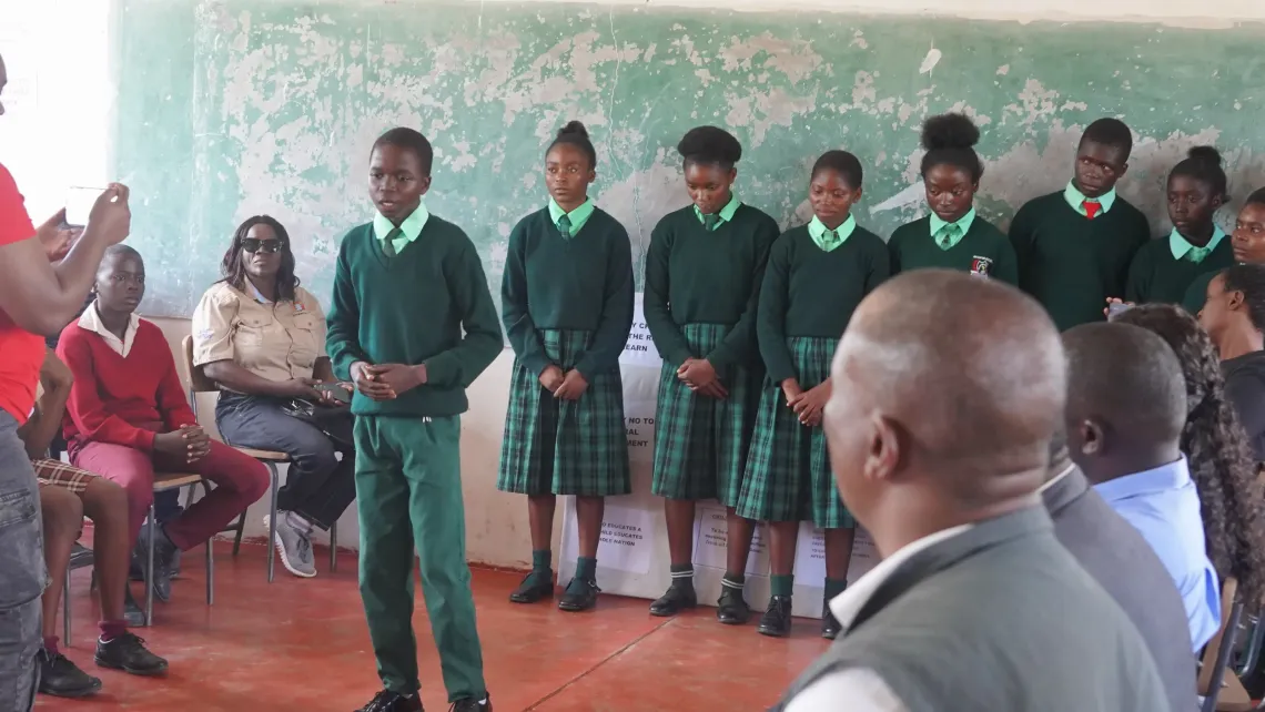 A learner presents to peers and officials during a school engagement in Chifunabuli District, Luapula Province.