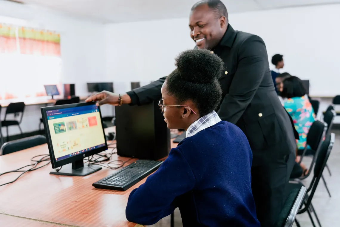 ICT teacher Collins Chipasa guides a learner through the Zambia Learning Passport during a digital learning session at St. Monica's Girls' Secondary School.