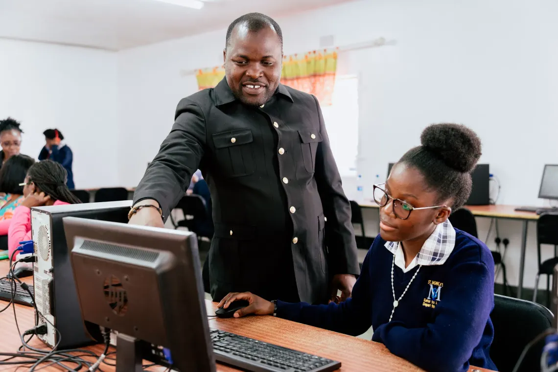 ICT teacher Collins Chipasa guides a learner through the Zambia Learning Passport during a digital learning session at St. Monica's Girls' Secondary School.