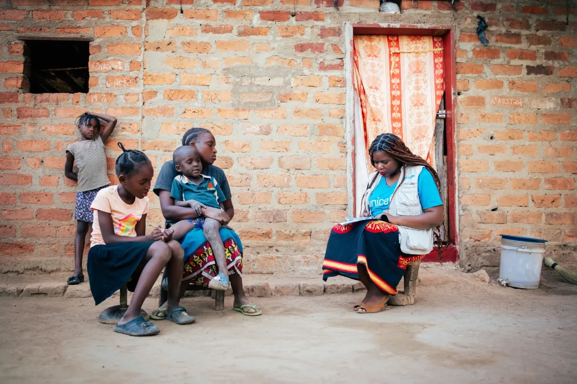 Caren Mutinta and her family during an interview with UNICEF staff Tikulirekuti Banda. 