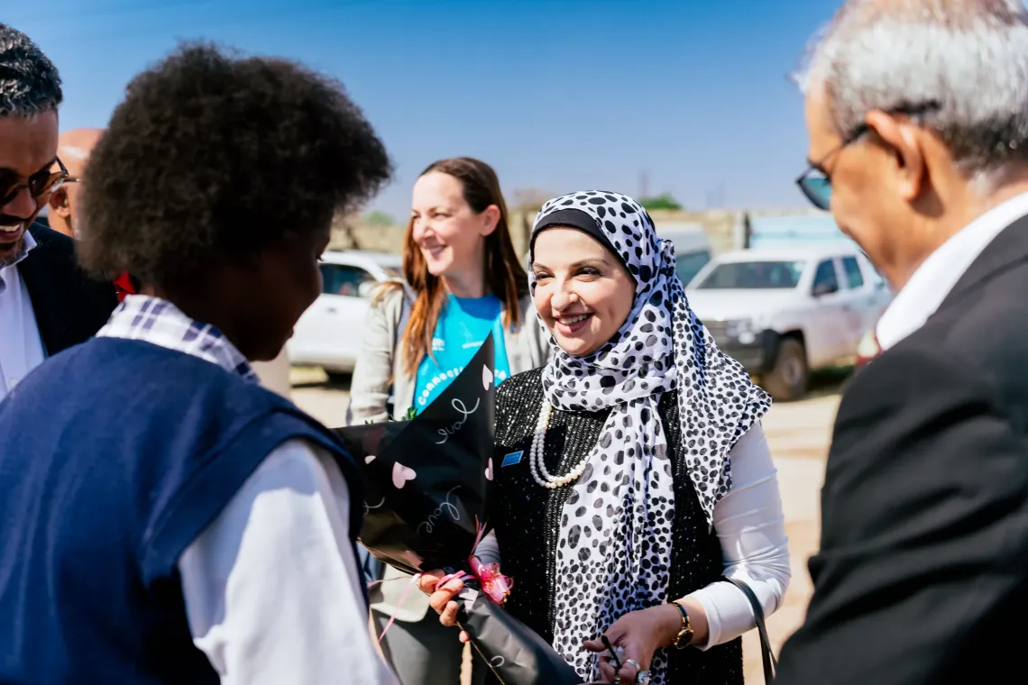 Dr. Saja Farooq Abdullah, UNICEF Zambia Representative, smiles as learners welcome her and Sunil Taldar, Airtel Africa Chief Executive Officer, with bouquets of flowers at St. Monica's Girls' Secondary School in Lusaka.