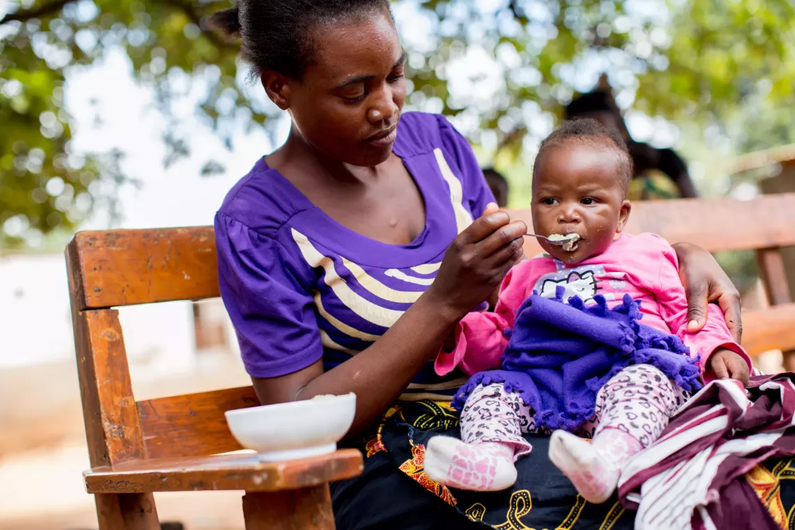 A mother feeding her child.