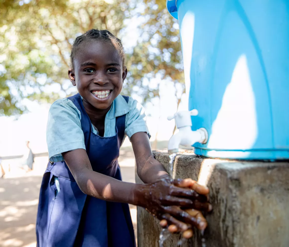 Child washing her hand.