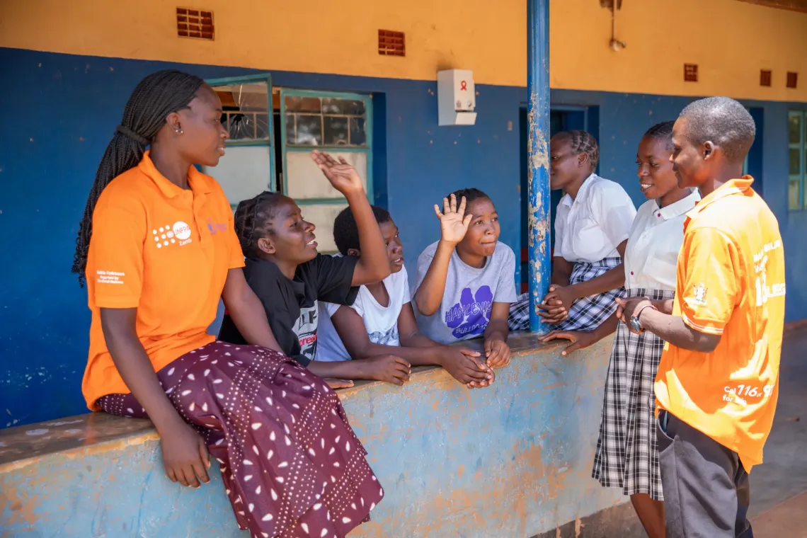 Adolescents engage in a peer-led session outside the Adolescent Friendly Space at Chimutende Rural Health Facility. 