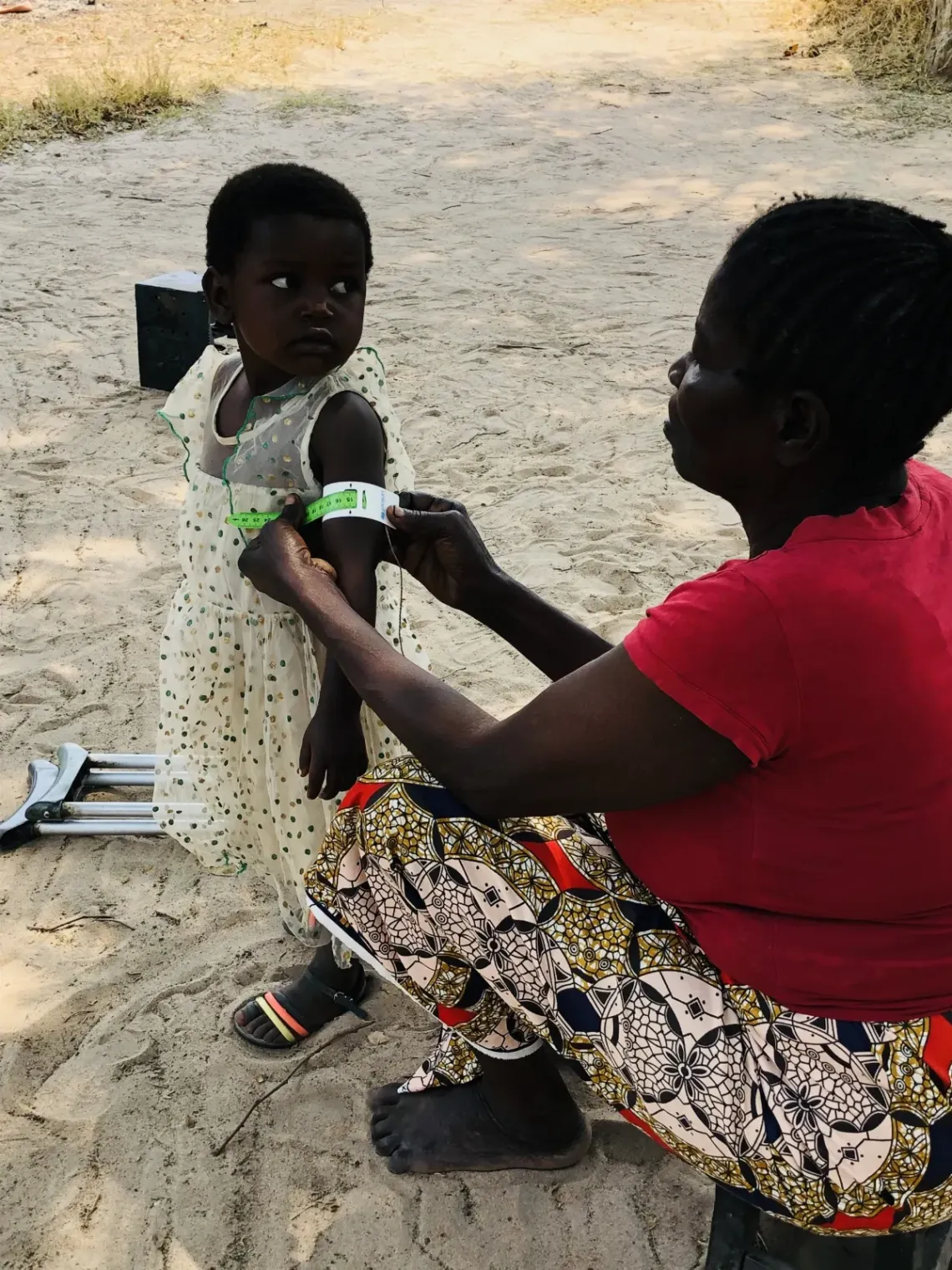 Elisa Kazhibaki assesses a child&rsquo;s malnutrition status using a MUAC tape within her community.