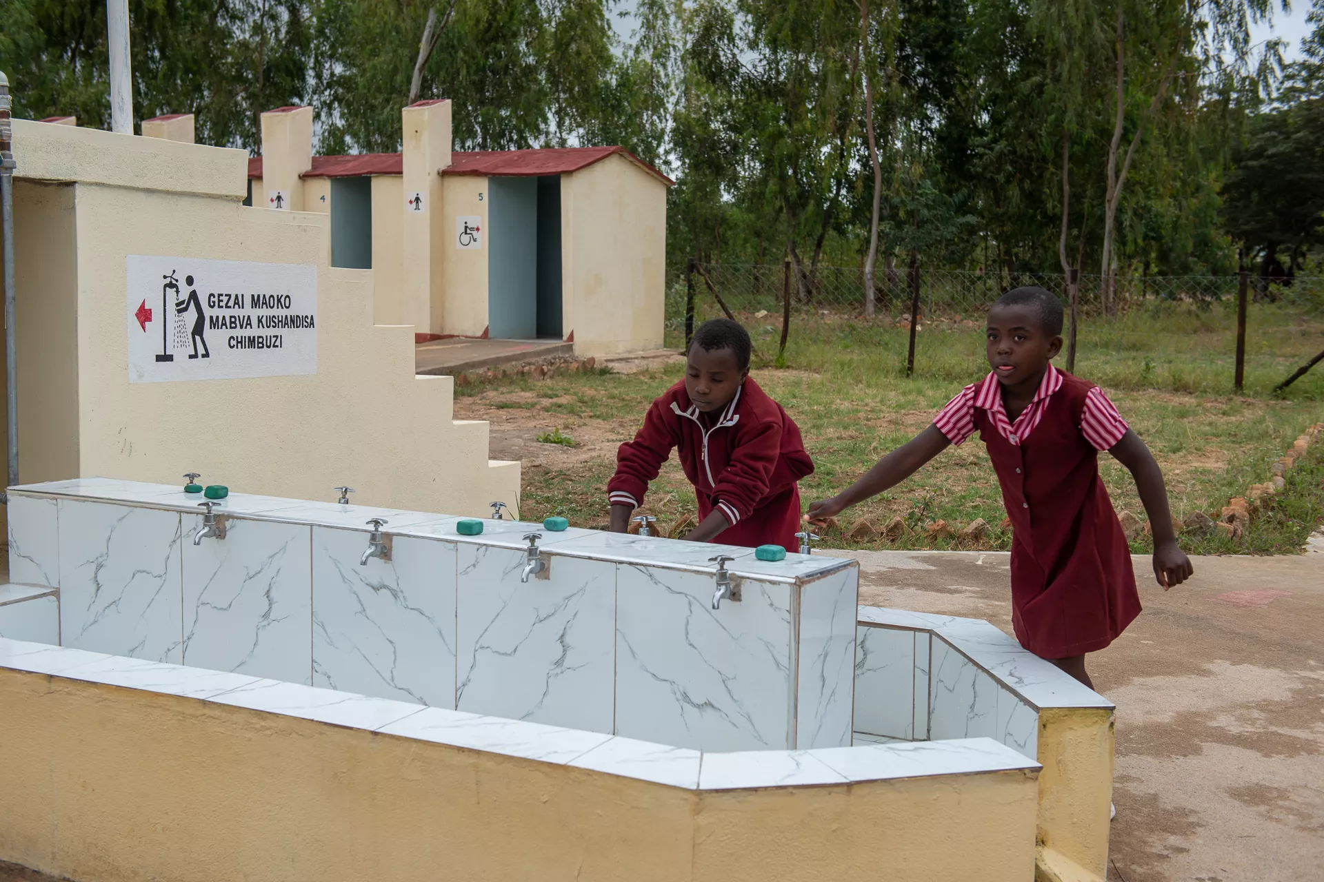 Two young girls washing hands at school